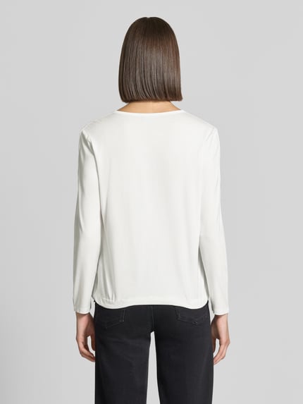 Vrouwenmodel draagt Regular Fit Bluse mit Brusttaschen van monari, witte blouse met lange mouwen, rechte ruglengte, detailopname rugaanzicht