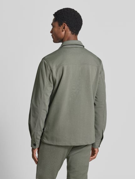 Männermodel trägt Slim Fit Hemdjacke mit Viskose-Anteil von Lindbergh in Olivgrün, elastischer Stoff, Rückenansicht, Ganzkörperansicht Rückansicht.