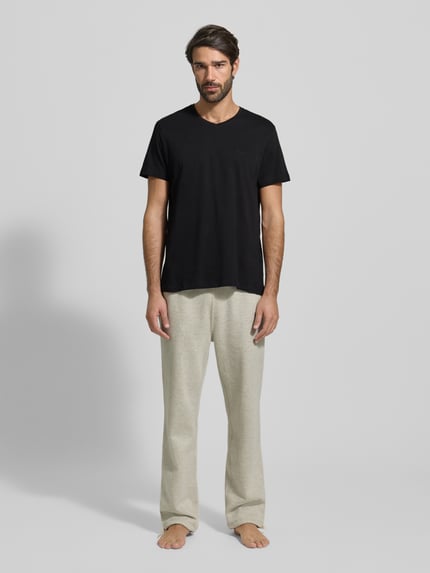 Męski model nosi czarne T-shirt z dekoltem w serek, proste cięcie, czysta bawełna, model 'ComfortS' od BOSS, zdjęcie całej sylwetki z przodu.