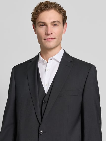 Männermodel trägt Slim Fit 2-Knopf-Sakko mit Pattentaschen Modell 'Tobias' van Carl Gross, zuiver scheerwol, reverskraag, detailopname bovenlichaam