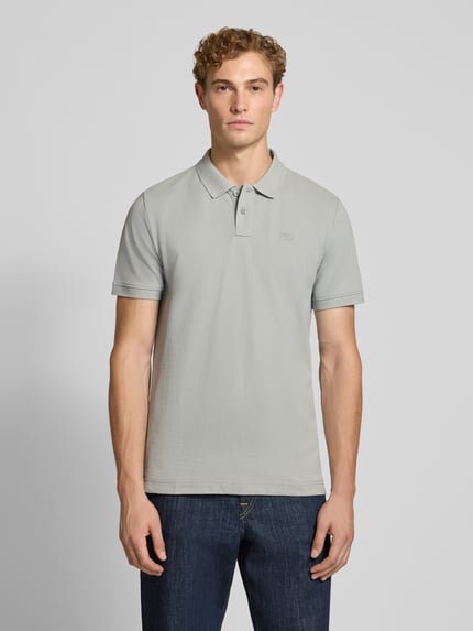 Männermodel trägt Regular Fit Poloshirt aus Baumwoll-Mix von Tom Tailor in Hellgrau, glatte Struktur, klassische Passform, Ganzkörperansicht von vorne, Herren Poloshirt von Tom Tailor.