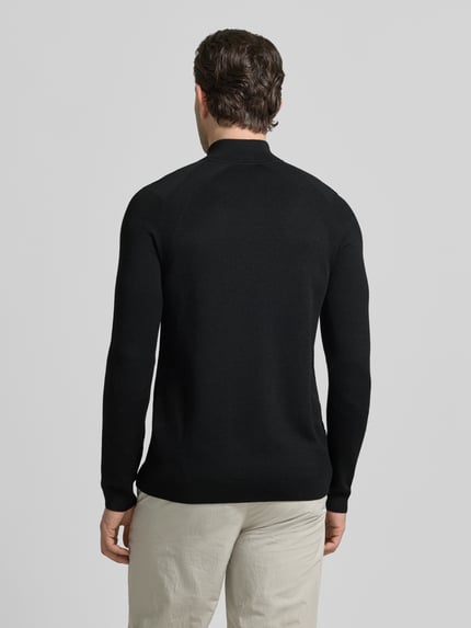 Männermodel trägt Regular Fit Troyer mit Schurwoll-Anteil Modell 'TOUR SEAMLESS QZ' von BOSS Green, unifarben schwarz, Jacquard, Ganzkörperansicht Rückansicht