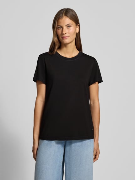Frauenmodel trägt Regular Fit T-Shirt mit Label-Emblem Modell 'Dala' von MOS MOSH, schwarzer Jersey, Rundhalsausschnitt, Kurzarm, Ganzkörperansicht von vorne, Rückenlänge bei Größe S 58 cm.