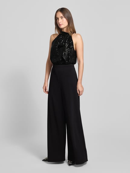 Kobiece model prezentuje Regular Fit Jumpsuit mit Pailettenbesatz od Swing, czarny, bez rękawów, z wiązaniem i cekinami, całość z przodu.