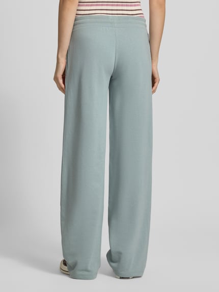 Vrouwenmodel draagt Straight Fit Sweatpants met tunnelkoord van REVIEW in lichtblauwe katoenmix, straight fit, elastische band, binnenbeenlengte maat S 85 cm, geheel van achteren