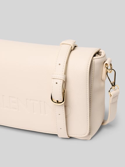 Produktfoto, Handtasche mit Logo-Prägung Modell 'Foxy' von VALENTINO BAGS in Creme mit Strukturmuster, goldener Schnalle, Detailaufnahme. Hauptfach mit Reißverschluss, abnehmbarer Schulterriemen, Magnetverschluss, Innenfach mit Zipper, Maße: 27x18x8 cm, Riemenlänge 130 cm.