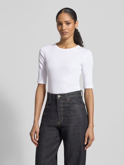 Frauenmodel trägt Regular Fit Longsleeve mit Rundhalsausschnitt Modell 'Selay' von Drykorn, reine Baumwolle, weiß, Strukturmuster, Halbarm, Ganzkörperansicht von vorne.