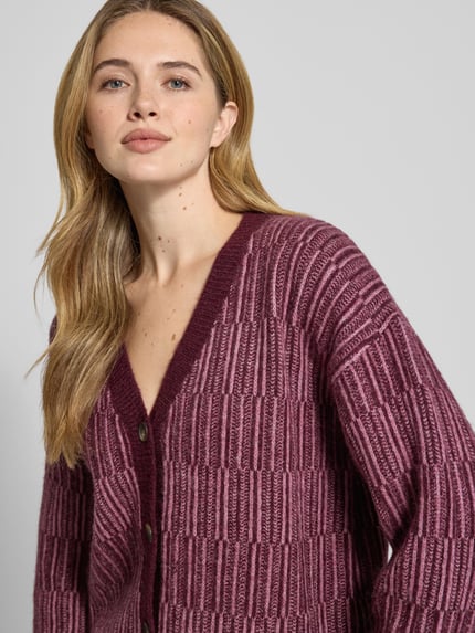 Frauenmodel trägt Relaxed Fit Strickpullover aus Woll-Mix mit Alpaka-Anteil Modell 'FALVA' von Selected Femme in Beere mit Strukturmuster, Nahaufnahme Oberkörper.