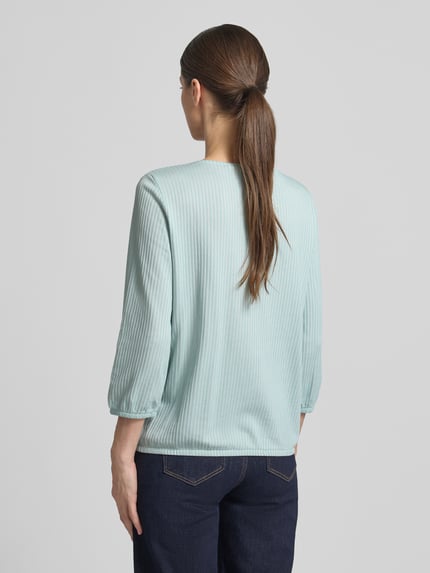 Frauenmodel trägt Regular Fit T-Shirt aus Baumwoll-Mix von Tom Tailor in Hellblau, gestreift, elastische Abschlüsse, Feinripp, Ganzkörperansicht Rückansicht.