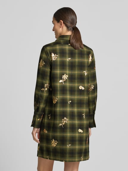 Frauenmodel trägt Knielanges Hemdblusenkleid mit Pailletten Modell 'MARTERA' von 0039 Italy, grün gemustert, Material-Mix, Ganzkörperansicht Rückansicht.