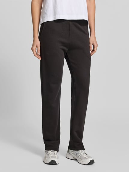 Vrouwenmodel draagt zwarte sweatpants uit mix van katoen en modal van Juvia met steekzakken, elastische band en tunnelkoord, los model, binnenbeenlengte maat S 74 cm, bandwijdte maat S 38 cm, voorkant detailopname.