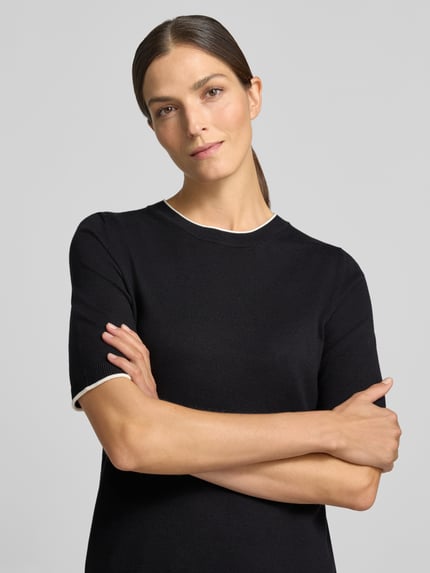 Frauenmodel trägt Regular Fit Pullover aus Viskose-Mix von s.Oliver BLACK LABEL in Schwarz mit weißen Details, Nahaufnahme Oberkörper.