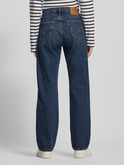 Frauenmodel trägt Jeans mit 5-Pocket-Design von Levi's®, dunkelblauer Baumwoll-Elasthan-Mix, gerader Schnitt, Ganzkörperansicht Rückansicht.