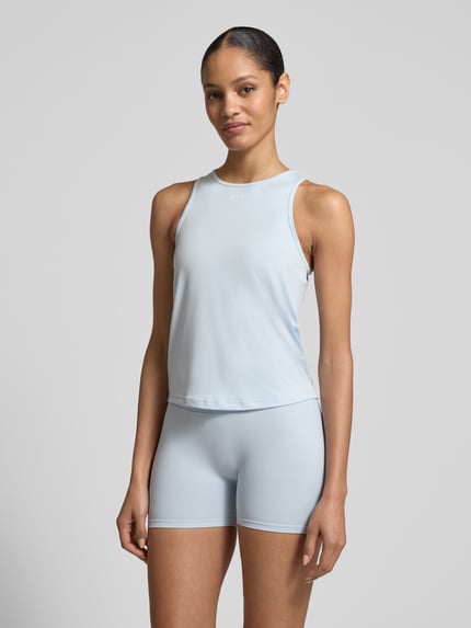 Vrouwenmodel draagt Top met Rundhalsausschnitt und Logo van aim'n, materiaalmix met stretch, regular fit, ronde hals, ruglengte maat S 54 cm, lichtblauw, gladde textuur, Ganzkörperansicht van voren.