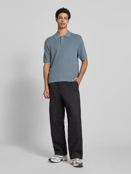 Männermodel trägt Regular Fit Poloshirt aus reiner Baumwolle von Marc O'Polo Denim, Optik: Unifarben, Strickstruktur, Label-Patch, Ganzkörperansicht von vorne.
