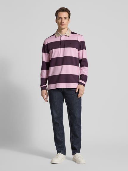 Männermodel trägt Regular Fit Poloshirt mit streepmotief en labelstitching van Fynch-Hatton, puur katoen, polokraag, knoopsluiting, shirt met lange mouwen, donker- en lichtroze tinten, geheel van voren, ganzkörperansicht von vorne.