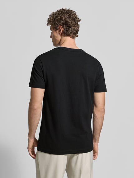 Männermodel trägt T-Shirt aus Baumwolle mit Rundhalsausschnitt von Christian Berg Men, czarny kolor, krój regular fit, widoczne label-detail, widok całej sylwetki z tyłu