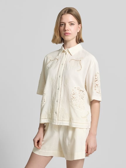 Frauenmodel trägt Bluse aus Leinen-Baumwoll-Mix mit Motiv-Stitching von Jake*s Casual, Farbton Creme, gerader Schnitt, Hemdblusenkragen, Knopfleiste, 3/4-Arm, luftige Struktur, Motiv-Stitching, Rückenlänge 57 cm, Ärmellänge 27 cm, Ganzkörperansicht von vorne.