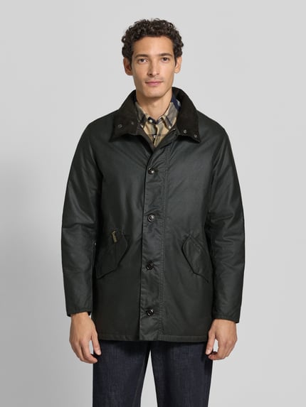 Männermodel trägt Regular Fit Parka aus reiner Baumwolle von Barbour in dunklem Grün, matte Textur, Ganzkörperansicht von vorne. Herren Parka