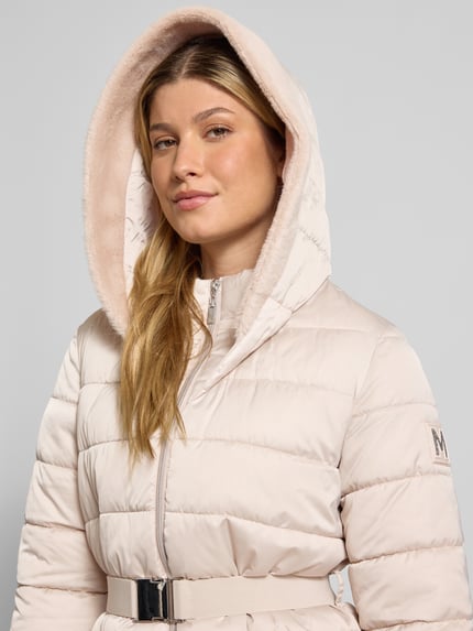 Frauenmodel trägt Steppjacke mit Reißverschlusstaschen und Gürtel von monari, Slim Fit, Kapuze mit Kunstfell, Nahaufnahme Oberkörper.