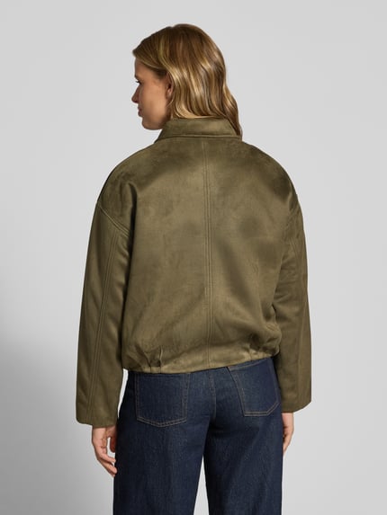 Frauenmodel trägt Regular Fit Blouson in Leder-Optik Modell 'AMBER' von ONLY, olivegrün, strukturierte Oberfläche, Damen Bomberjacke, Ganzkörperansicht Rückansicht.
