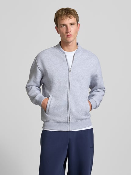 Männermodel trägt Gezippte Sweatjacke mit College-Kragen von REVIEW, hellgrau, Regular Fit, seitliche Eingrifftaschen, Nahaufnahme Oberkörper, Baumwoll-Mix, Rückenlänge 69 cm, Ärmellänge 63 cm.