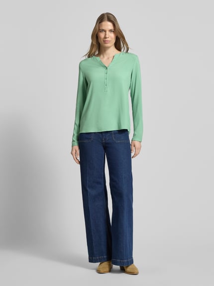 Frauenmodel trägt Regular Fit Bluse aus reiner Viskose mit Tunika-Ausschnitt von Christian Berg Woman in Grün mit Knopfleiste und langärmeligem Design, passend für Damen, Ganzkörperansicht von vorne.
