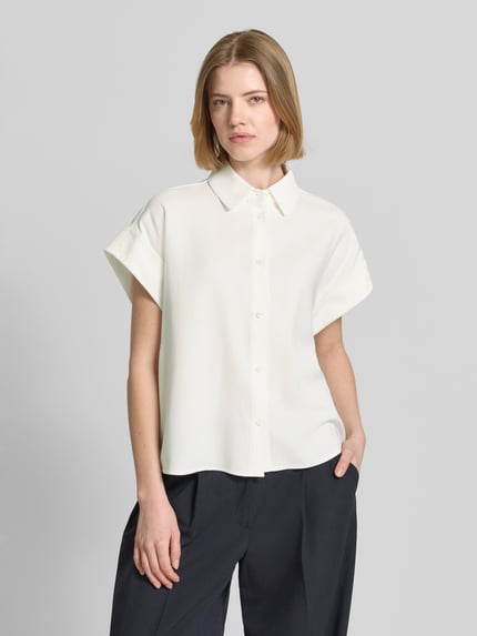 Frauenmodel trägt Boxy Fit Bluse aus Viskose-Mix Modell 'Zelya' von Someday in Weiß, Hemdblusenkragen, kurze Ärmel, Nahaufnahme Oberkörper.