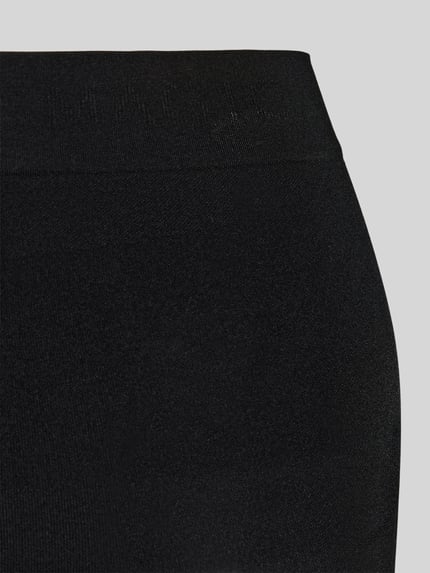 Vrouwenmodel draagt figurvormende slip Comfort & Seamless Shaper van MAGIC Bodyfashion, zwart, naadloos, detailopname taille.