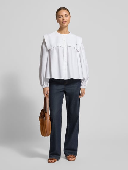 Modelka kobieca nosi białą hemdbluzę z matrosenkragen Polo Ralph Lauren z czystej bawełny, luźny krój, bufiaste rękawy, guzik, długość tyłu 56 cm, długość rękawa 57 cm, przedni widok całej sylwetki.