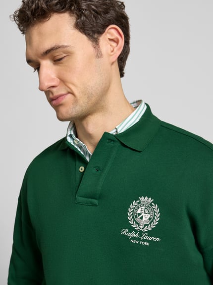 Männermodel trägt Regular Fit Sweatshirt aus Baumwoll-Mix von Polo Ralph Lauren in Grün mit Label Print und Polokragen, Nahaufnahme Oberkörper.