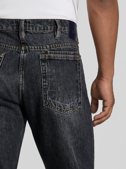 Männermodel trägt Straight Fit Jeans aus reiner Baumwolle von Paul Smith, dunkle Waschung, 5-Pocket-Design, Nahaufnahme Rückansicht.
