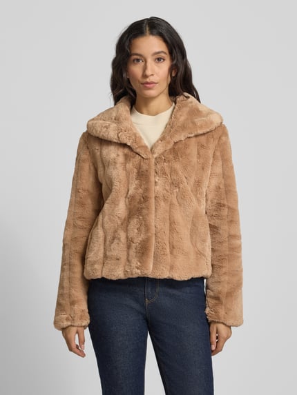 Frauenmodel trägt Jacke aus Kunstfell Modell 'NEW SOPHY' von Guess in Beige, Regular-Fit, Schalkragen, Ganzkörperansicht von vorne, Rückenlänge bei Größe S 56 cm, Schulterbreite 44 cm, Brustweite 46 cm, Ärmellänge 59 cm.