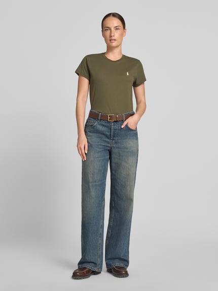 Vrouwenmodel draagt Regular Fit T-shirt uit puur katoen van Polo Ralph Lauren in olijfgroen, met blauwe jeans, volledige vooraanzicht.