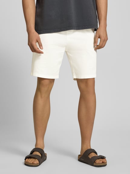 Męski model ma na sobie Straight Fit Shorts mit Gesäßtasche od REVIEW, bawełna, krój straight fit, kieszeń z tyłu, materiał stylizowany na len, elastyczny pas, szerokość w rozmiarze M: 44 cm, długość wewnętrzna nogawki w rozmiarze M: 21 cm, jasny kolor, prosty fason, gładka tekstura, całe ciało z przodu.