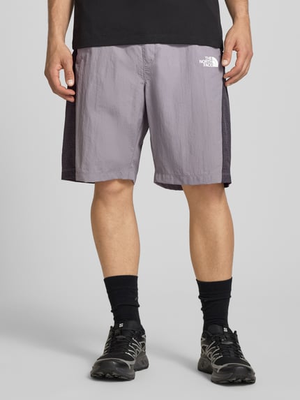 Männermodel trägt Shorts mit Logo und Gürtel von The North Face, Regular-Fit, elastischer Bund, Bundweite 42 cm, Ganzkörperansicht von vorne.