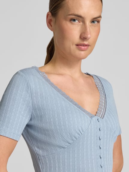 Frauenmodel trägt T-Shirt mit Spitzenbesatz und Knopfleiste von Jake*s Casual, hellblauer Material-Mix mit Stretch-Anteil, V-Ausschnitt, Slim-Fit, Nahaufnahme Oberkörper.