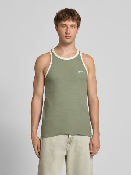Männermodel trägt Slim Fit Top mit Logo-Stitching von KARL KANI in Grün mit Strukturmuster und Rundhalsausschnitt, Reine Baumwolle, Ganzkörperansicht von vorne. Rückenlänge bei Größe M: 68 cm.