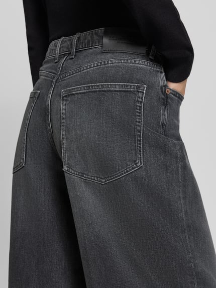Frauenmodel trägt Relaxed Fit Jeans aus Baumwoll-Mix Modell 'MAJ' von Marc O'Polo, grauer Denim mit heller Waschung und sichtbarer Textur, Nahaufnahme Rückansicht, Damen Barrel Jeans von Marc O'Polo.