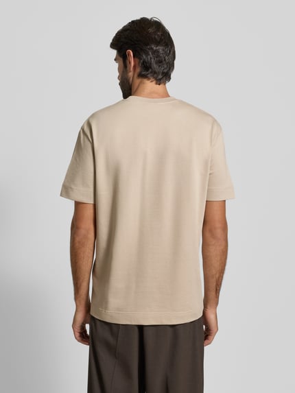 Männermodel trägt T-Shirt mit Label-Detail Modell 'Achilleas' von JOOP! Collection, beige, Reine Baumwolle, Regular-Fit, Rückenlänge 63 cm, Ganzkörperansicht Rückansicht.
