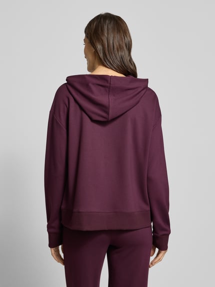 Frauenmodel trägt Hoodie aus Viskose-Mix mit Känguru-Tasche und Pailletten von Milano Italy in dunklem Lila, Relaxed-Fit, Ganzkörperansicht Rückansicht.