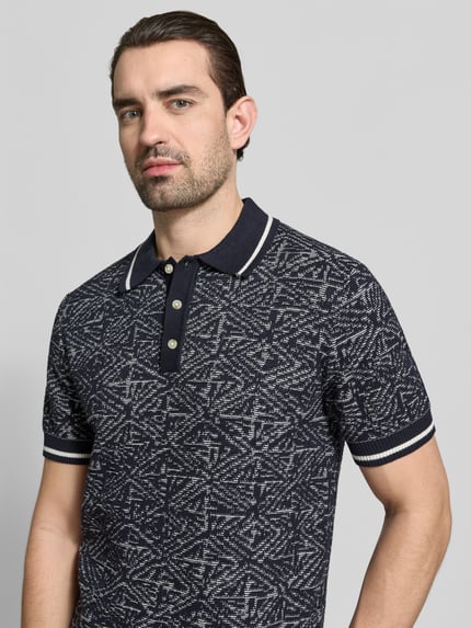Männermodel trägt Regular Fit Poloshirt im Allover-Look von Jack & Jones Premium aus reiner Baumwolle mit Polokragen und Knopfleiste, Nahaufnahme Oberkörper.
