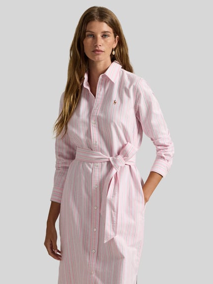 Vrouwenmodel draagt Oxford-Hemdblusenkleid met Gürtel van Polo Ralph Lauren, All-over streepmotief in roze en wit, puur katoen, midilengte, gestikt logo, tailleriem, knoopsluiting, lange mouwen met manchet, steekzakken, oxford verwerking, Ganzkörperansicht van voren.