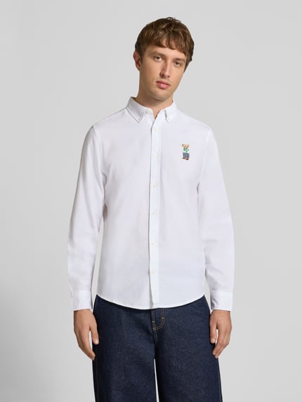 Männermodel trägt weißes Slim Fit Freizeithemd mit Button-Down-Kragen von CHILL PILL, Motiv-Stitching, reine Baumwolle, Ganzkörperansicht von vorne.