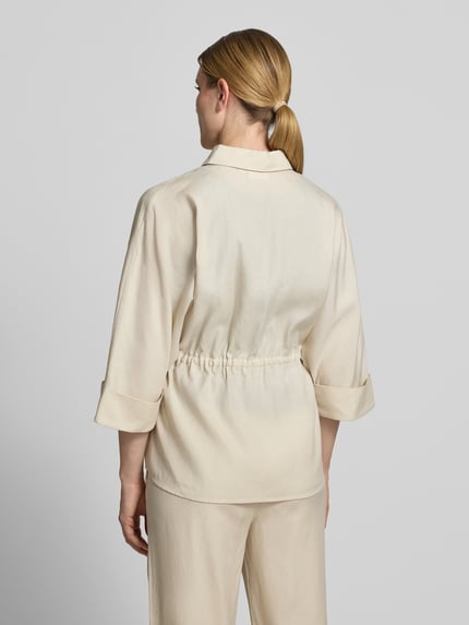 Frauenmodel trägt Relaxed Fit Bluse aus Lyocell-Mix mit 3/4-Arm von Comma, beige, Hemdblusenkragen, Tunnelzug, Rückenlänge 71 cm, Ganzkörperansicht Rückansicht.