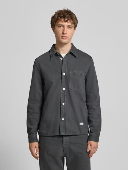 Männermodel trägt Regular Fit Hemdjacke aus reiner Baumwolle von Marc O'Polo DENIM in Dunkelgrau, weiße Knöpfe, Ganzkörperansicht von vorne.