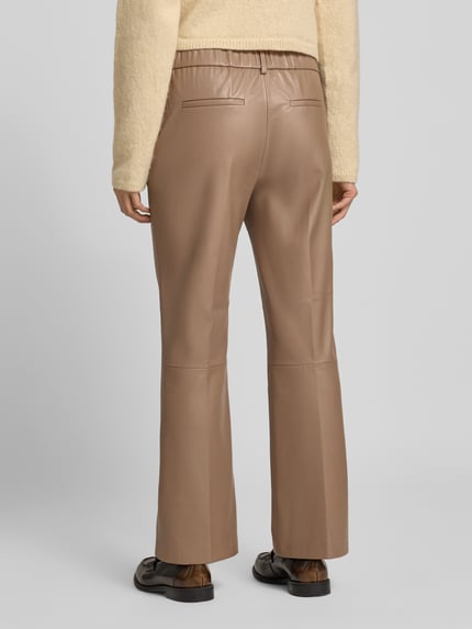 Vrouwenmodel draagt Loose Fit Pants in Leder-Optik Modell 'Luane' van OPUS PANTS, lichtbruin, gladde textuur, achteraanzicht volledig lichaam.
