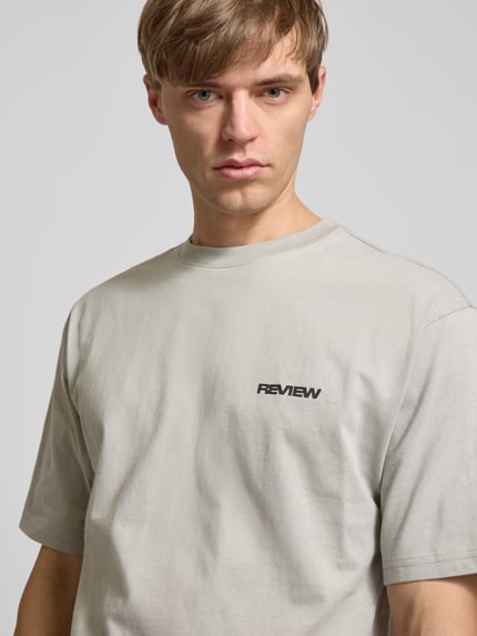 Männermodel trägt Relaxed Fit T-Shirt aus reiner Baumwolle von REVIEW, kurzärmelig mit Logo-Stickerei, Nahaufnahme Oberkörper.