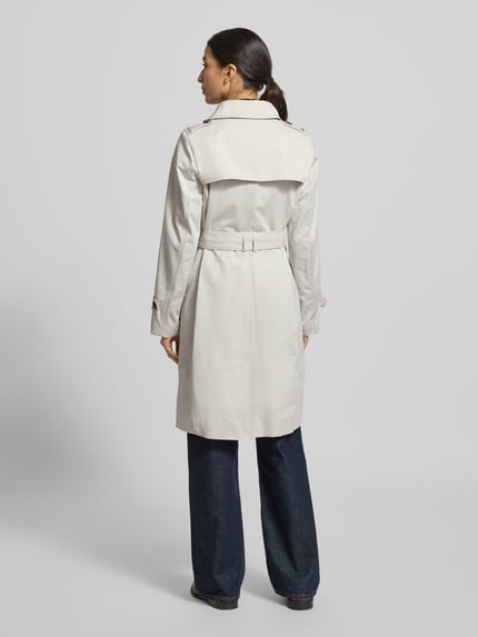 Modelka nosi Mantel mit Stoffgürtel von Jake*s Casual w kolorze jasnego beżu, materiał z domieszką bawełny, krój slim fit, pasek z materiału, kołnierz wykładany, kieszenie wpuszczane, listwa guzikowa, długość pleców w rozmiarze 36: 99 cm, szerokość ramion w rozmiarze 36: 40 cm, szerokość klatki piersiowej w rozmiarze 36: 41 cm, długość rękawa w rozmiarze 36: 64 cm, widok całej sylwetki od tyłu