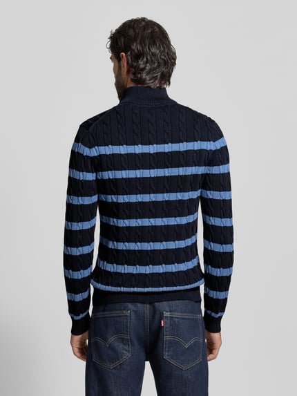 Męski model nosi Slim Fit Troyer in Strick-Optik od Gant, bawełna, krój slim fit, struktura swetra, naszywane logo, widok całej sylwetki z tyłu.